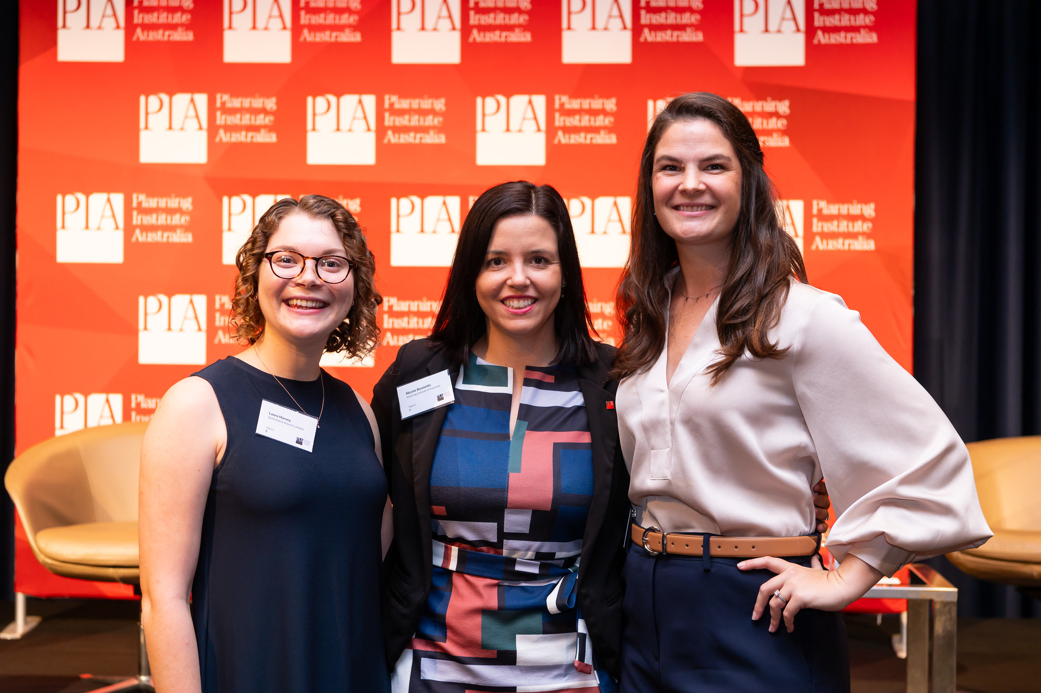 three professional woman smiling at the camrs